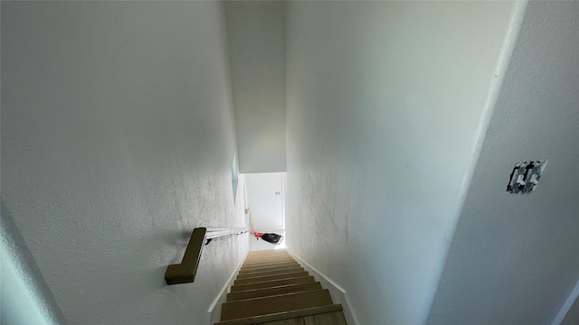 staircase with baseboards and a textured wall