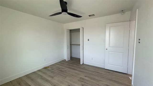 unfurnished bedroom with visible vents, ceiling fan, baseboards, wood finished floors, and a closet