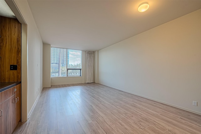 unfurnished living room featuring light wood-style flooring and baseboards