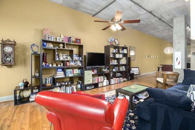 living room with wood finished floors, baseboards, and ceiling fan