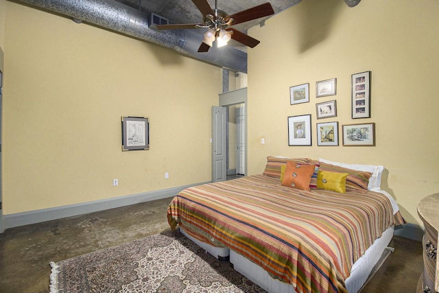 bedroom featuring baseboards, visible vents, concrete floors, ceiling fan, and a towering ceiling