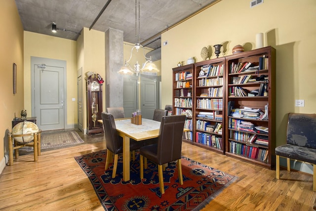 dining area with a high ceiling, wood finished floors, and visible vents