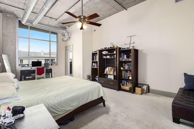 carpeted bedroom with visible vents, baseboards, and a high ceiling