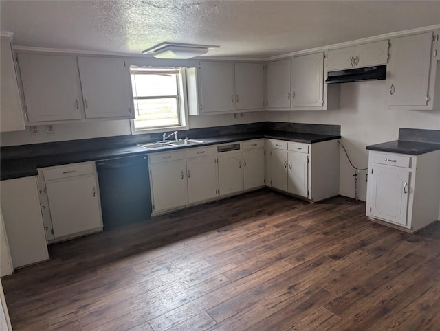 kitchen with dishwasher, dark wood-type flooring, dark countertops, and a textured ceiling