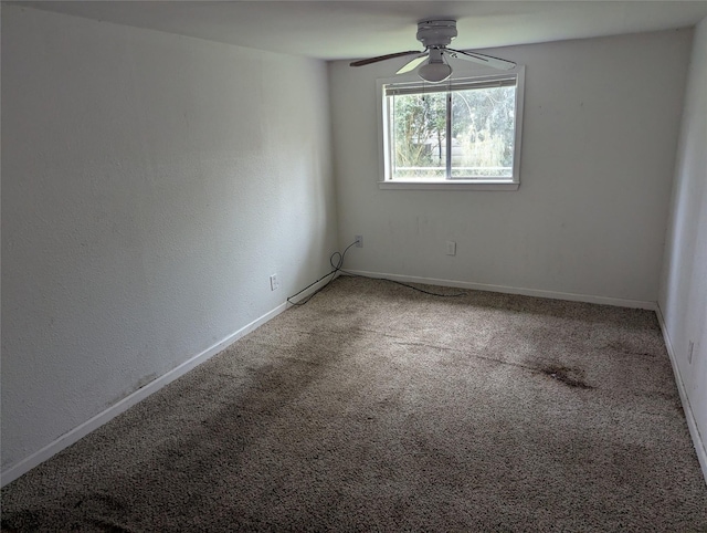 empty room with baseboards, carpet floors, and a ceiling fan