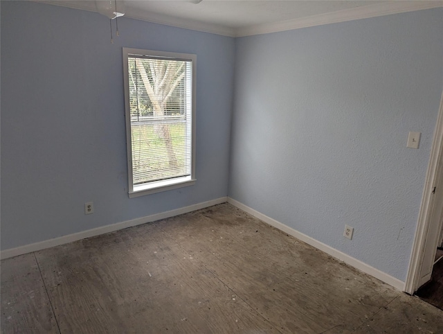 spare room with crown molding, a healthy amount of sunlight, and baseboards