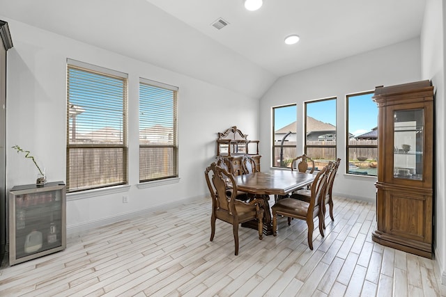 dining area with visible vents, baseboards, recessed lighting, vaulted ceiling, and light wood-type flooring