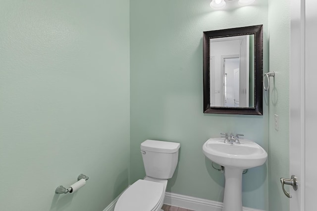 bathroom with toilet and baseboards