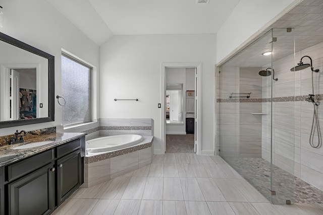 full bath with a stall shower, vanity, lofted ceiling, a bath, and a spacious closet