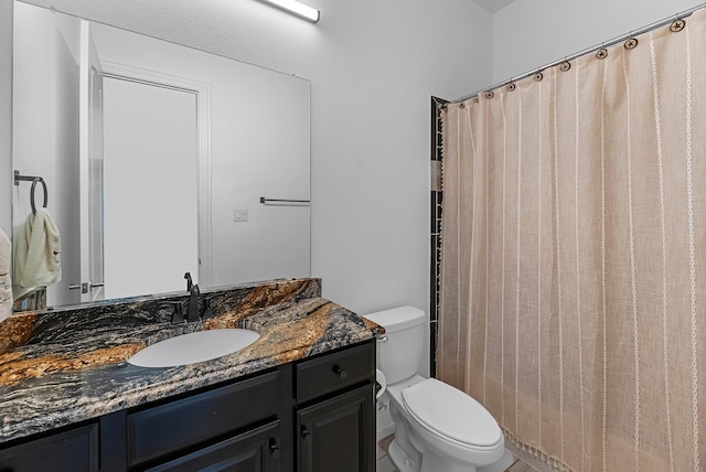 bathroom featuring toilet, vanity, and a shower with curtain