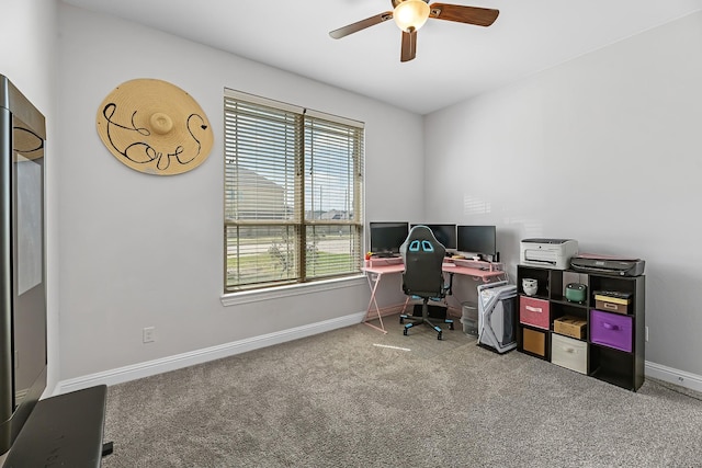 carpeted office space featuring baseboards and ceiling fan