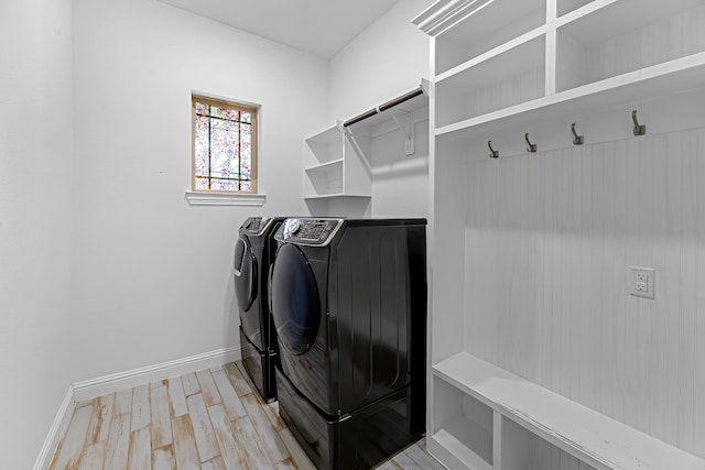 laundry room with laundry area, light wood-style flooring, baseboards, and independent washer and dryer