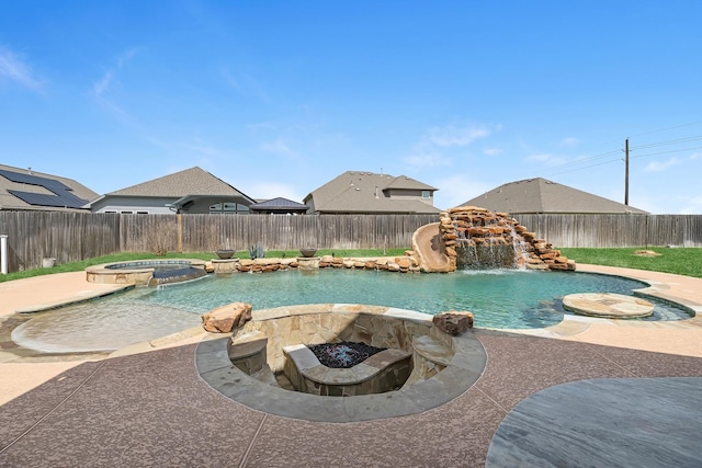 view of swimming pool with a fenced backyard and a pool with connected hot tub