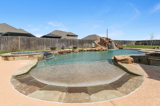 view of pool featuring a fenced backyard and a pool with connected hot tub