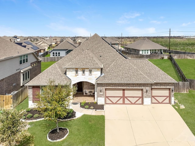 view of front facade featuring brick siding, a garage, a front lawn, and roof with shingles