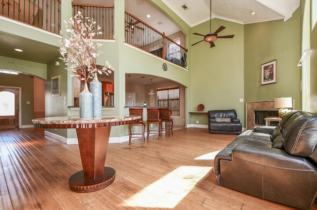 living area with visible vents, hardwood / wood-style flooring, a fireplace, baseboards, and ceiling fan