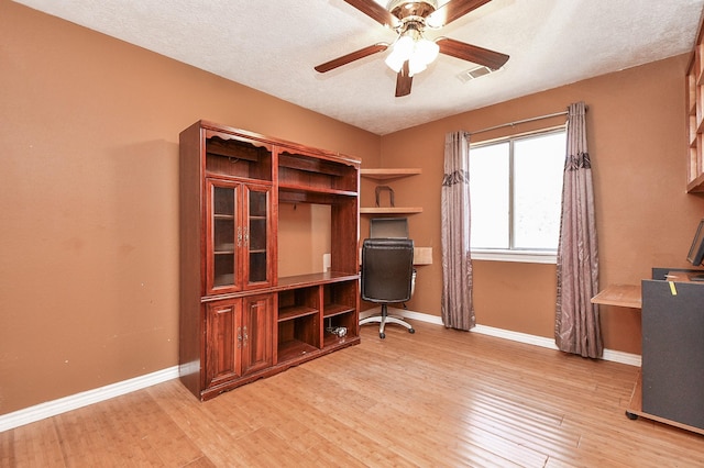 office area with baseboards, light wood-type flooring, and ceiling fan