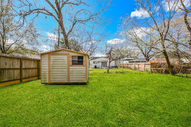 view of yard featuring a fenced backyard, a storage unit, and an outdoor structure