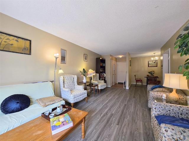 living room featuring baseboards, wood finished floors, a textured ceiling, and a chandelier