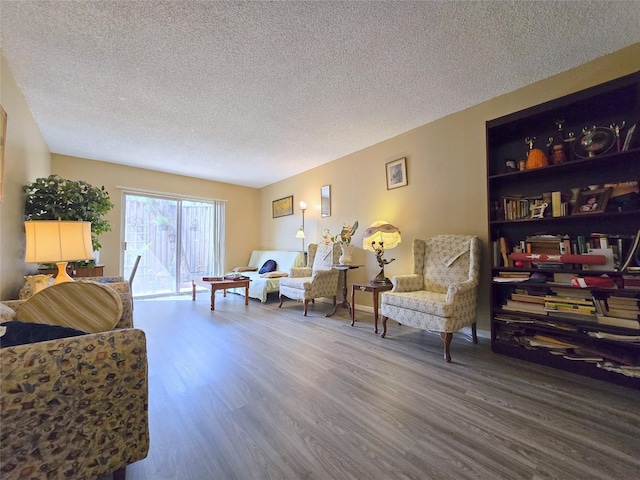 living area featuring a textured ceiling and wood finished floors