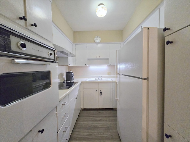 kitchen with oven, freestanding refrigerator, white cabinetry, wall chimney exhaust hood, and black electric cooktop