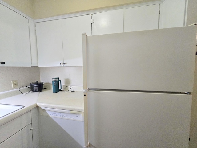 kitchen featuring white appliances, white cabinetry, and light countertops