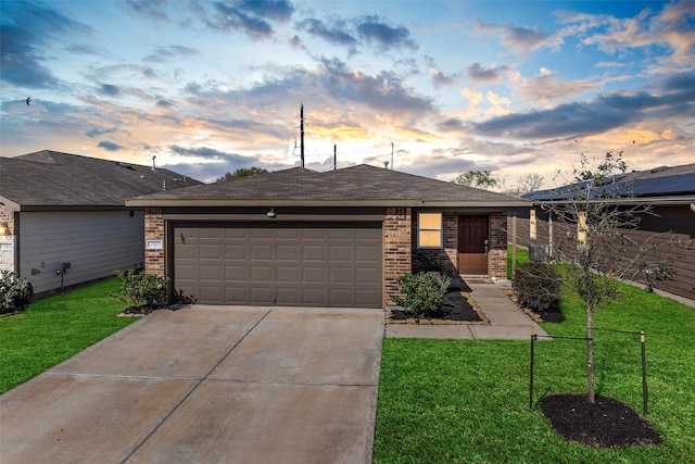 view of front of home with brick siding, a lawn, and driveway