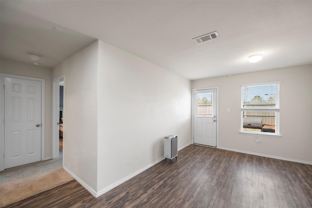 entrance foyer featuring dark wood-style floors, visible vents, and baseboards