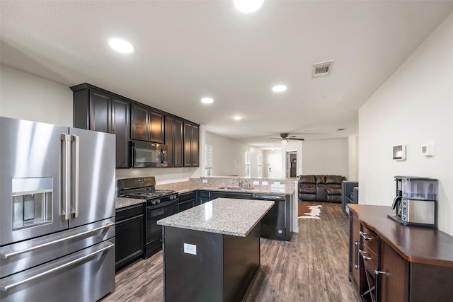 kitchen with visible vents, open floor plan, a peninsula, black appliances, and a ceiling fan