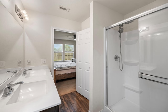 ensuite bathroom with a stall shower, visible vents, and a sink