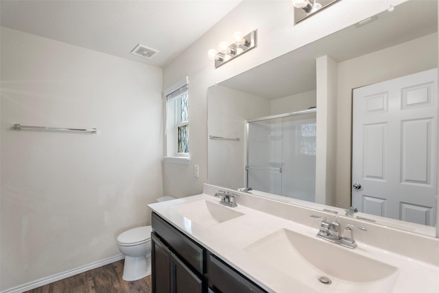 full bath with a shower stall, toilet, visible vents, and a sink