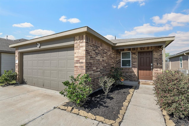 single story home with concrete driveway, an attached garage, and brick siding