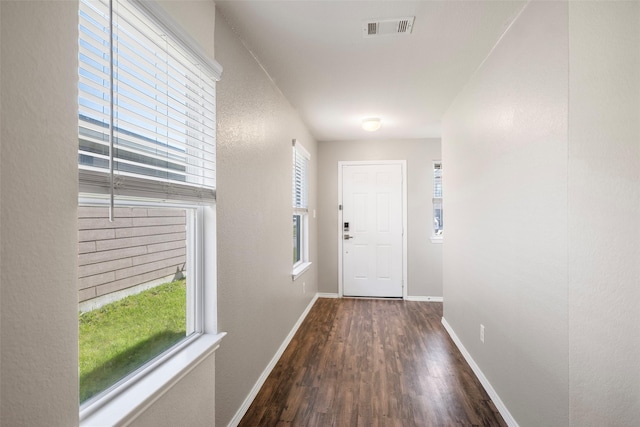 doorway with visible vents, baseboards, and wood finished floors