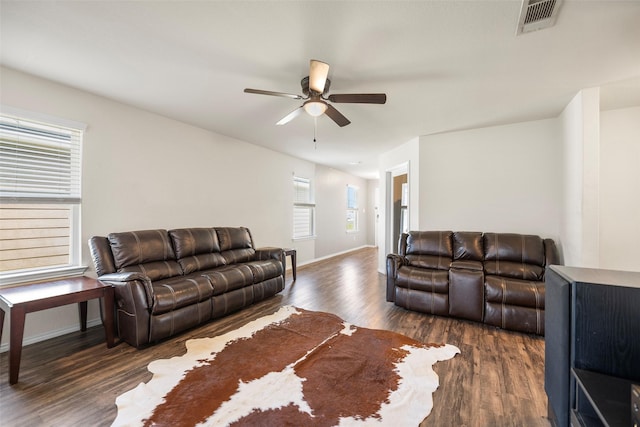 living room featuring visible vents, wood finished floors, baseboards, and ceiling fan