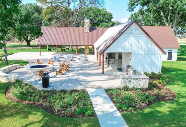 view of home's community featuring a patio area, a fire pit, and a lawn