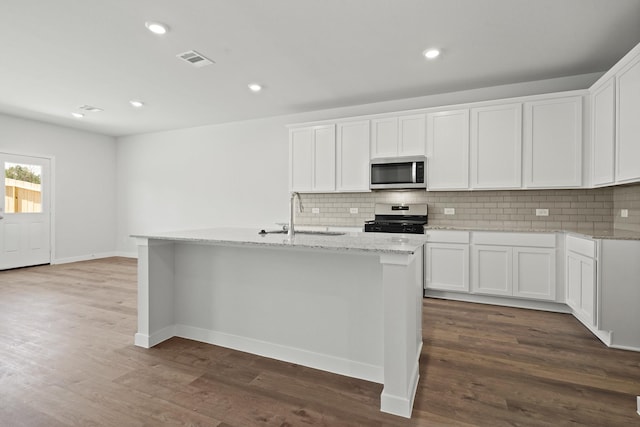 kitchen with visible vents, light stone countertops, appliances with stainless steel finishes, and decorative backsplash