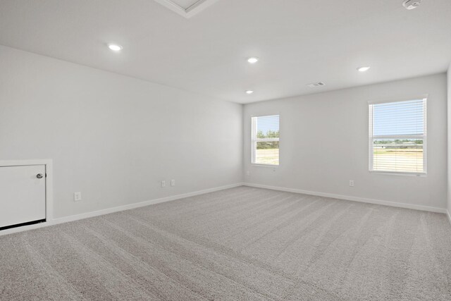 spare room featuring carpet flooring, recessed lighting, visible vents, and baseboards