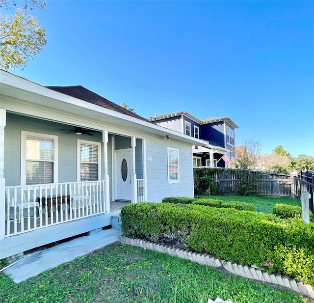 view of front facade with a porch, fence, and ceiling fan