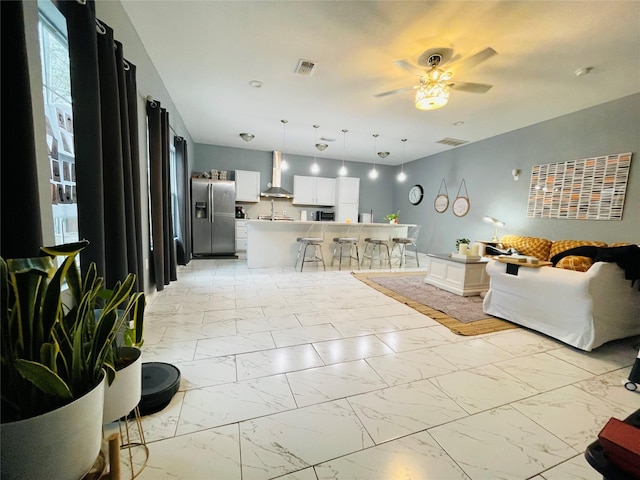 living area with visible vents, marble finish floor, and ceiling fan