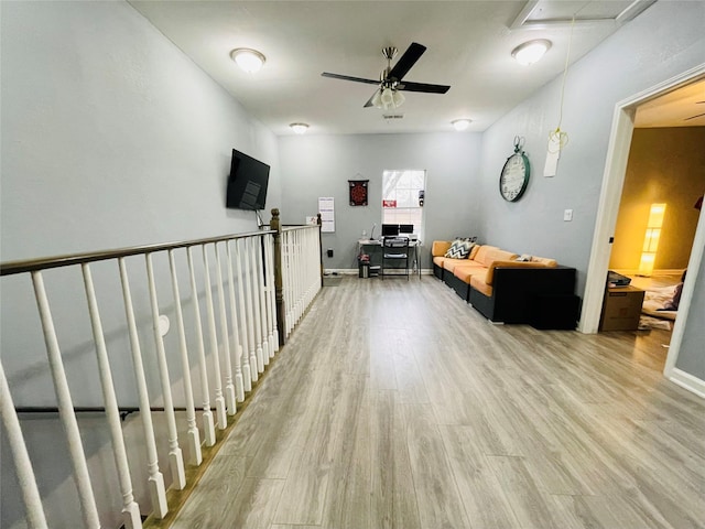 hallway featuring light wood-type flooring, baseboards, and attic access