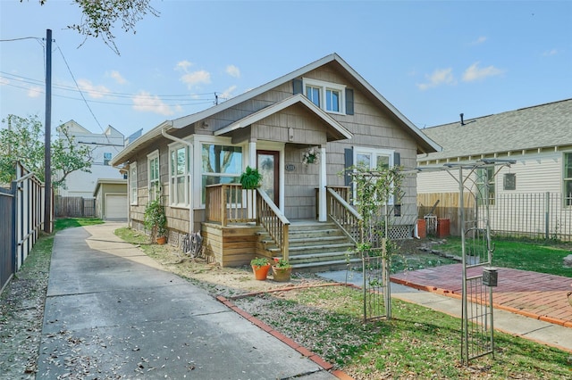 view of front of property featuring a garage, an outdoor structure, and fence