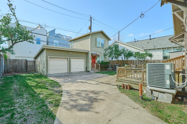 view of front of property with fence, central AC unit, driveway, an outdoor structure, and a garage