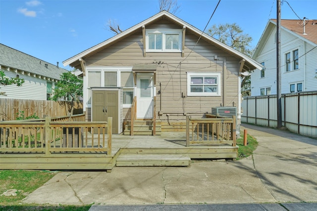 view of front facade with entry steps, a deck, and fence