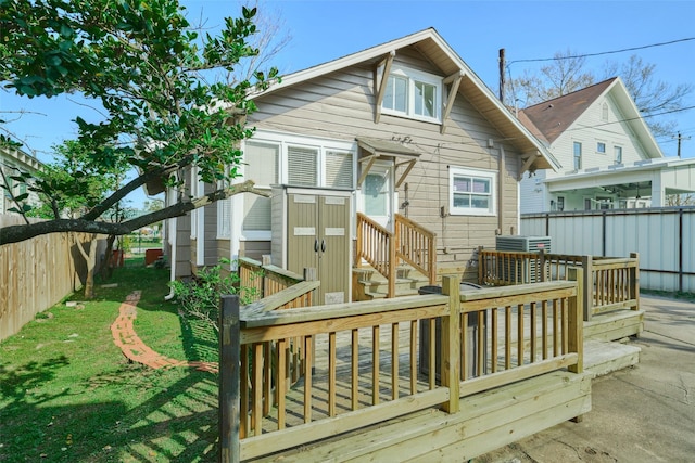 rear view of house with a yard, a deck, and a fenced backyard