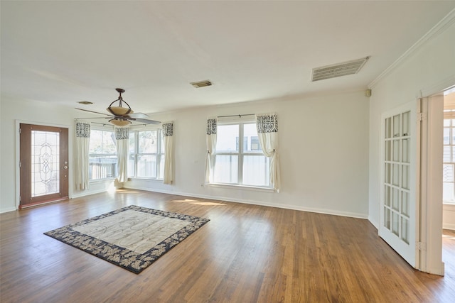 interior space featuring visible vents, wood finished floors, ceiling fan, and ornamental molding