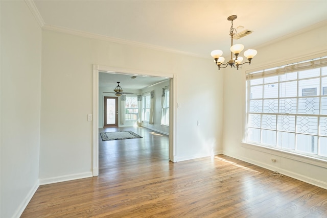 unfurnished room with baseboards, a notable chandelier, wood finished floors, and ornamental molding