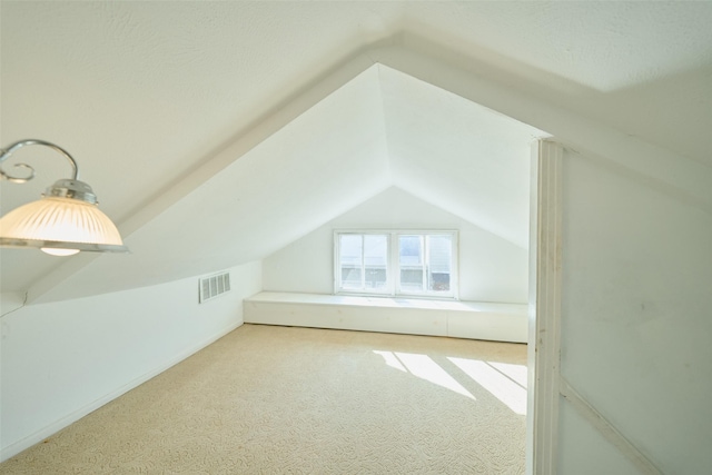 bonus room with visible vents, carpet flooring, and vaulted ceiling