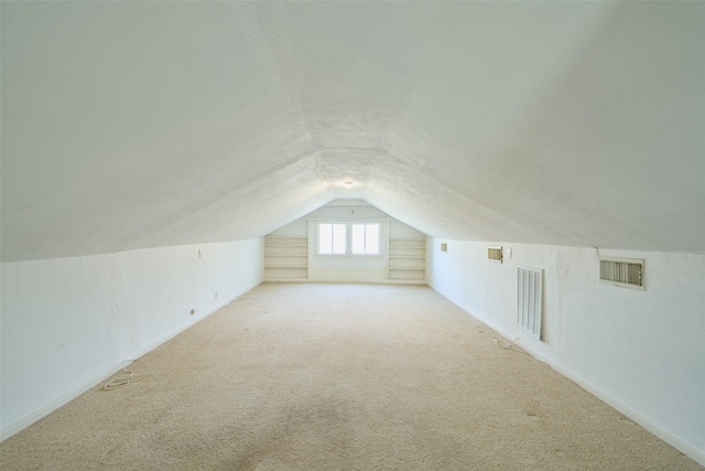 bonus room featuring built in features, visible vents, lofted ceiling, and carpet floors