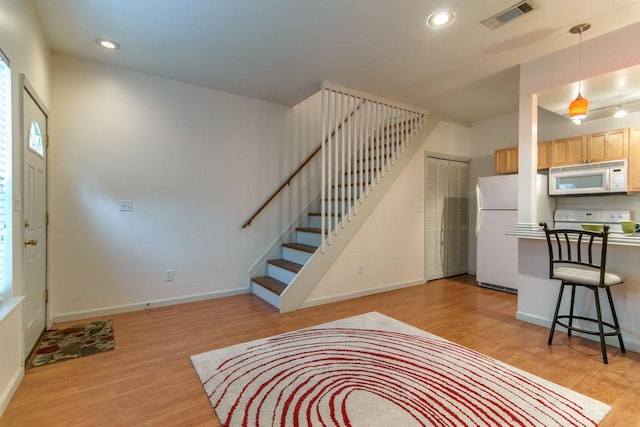 entryway with recessed lighting, visible vents, light wood-style flooring, and stairs