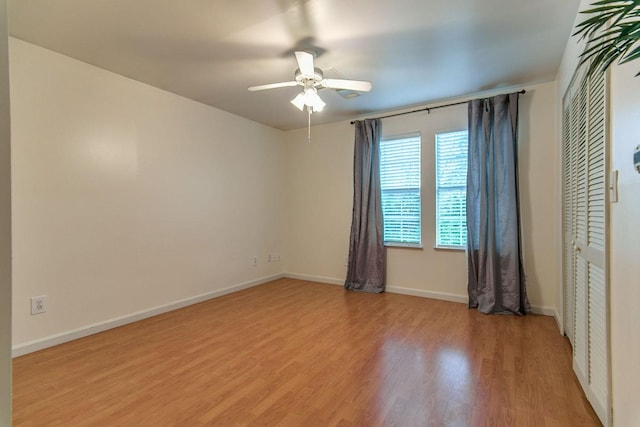 spare room with a ceiling fan, baseboards, and light wood finished floors